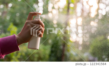 Unrecognizable woman using insect sprays disease prevention. Protection against mosquito bite during summertime. Safety skin treatment Unrecognizable woman using insect sprays disease prevention. Protection against mosquito bite during summertime. Safety skin treatment 122341564