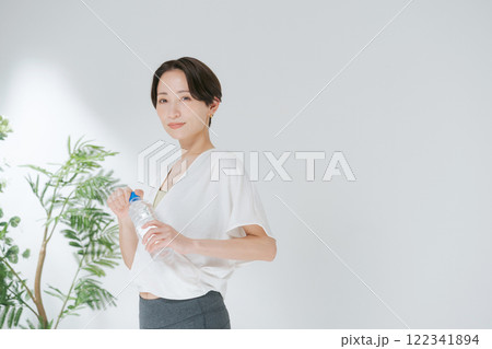ペットボトルの水を持つトレーニングウェアの女性 122341894