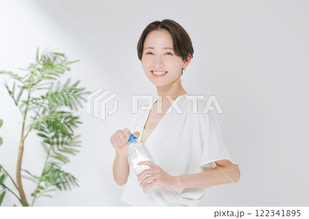 ペットボトルの水を持つトレーニングウェアの女性 122341895