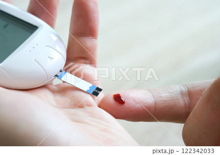 hand of people check diabetes and high blood glucose monitor with digital pressure gauge. Healthcare and Medical concept hand of people check diabetes and high blood glucose monitor with digital pressure gauge. Healthcare and Medical concept 122342033