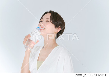 ペットボトルの水を飲むトレーニングウェアの女性 122342051