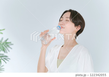 ペットボトルの水を飲むトレーニングウェアの女性 122342055