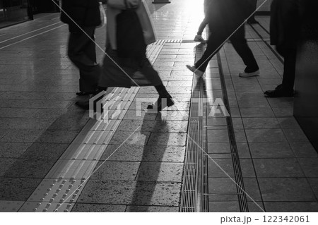 夕陽が街を歩く人を照らしシルエットで浮かぶ 122342061