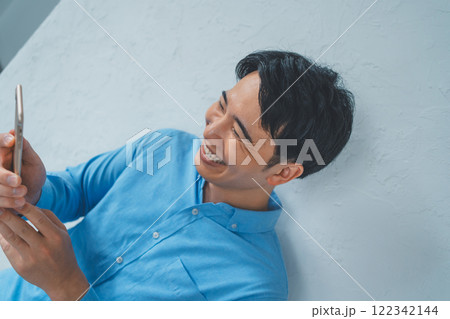 スマホを見て笑う男性 スマホを見て笑う男性 122342144