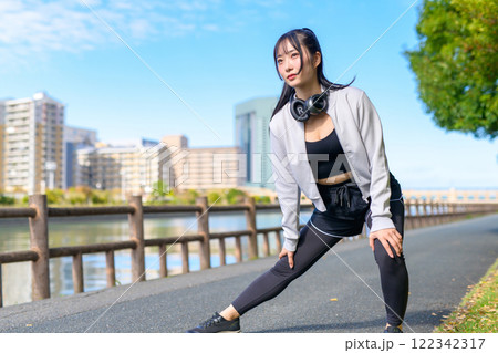 川沿いの歩道で脚のストレッチをするかっこいい女性 歩く ダイエット 散歩 運動 川沿いの歩道で脚のストレッチをするかっこいい女性 歩く ダイエット 散歩 運動 122342317