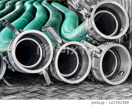 Industrial hoses arranged in a neat stack on checkered metal surface, highlighting functional design and durability 122342369