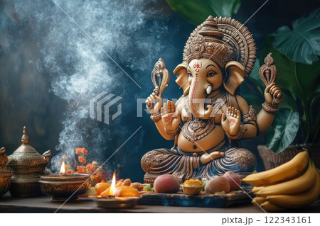 Golden ganesha statue holding a religious symbol, surrounded by incense smoke and offerings 122343161