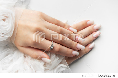 Bride showing her beautiful white nails and engagement ring 122343316