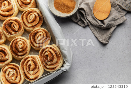 Cinnamon rolls prepared for baking with brown sugar and wooden spoon Cinnamon rolls prepared for baking with brown sugar and wooden spoon 122343319