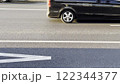 SUV driving through busy city traffic during rush hour. Dynamic urban scene with moving vehicles, sunlight on the road, energy-efficient commuting, and modern mobility. 122344377
