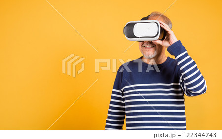 Portrait Asian smiling old man holding in a virtual reality glasses headset studio shot isolated yellow background, Excited happy senior man pensioner using VR play simulation game Portrait Asian smiling old man holding in a virtual reality glasses headset studio shot isolated yellow background, Excited happy senior man pensioner using VR play simulation game 122344743