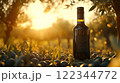 Bottle of extra virgin olive oil standing on olives at sunset in olive grove 122344772