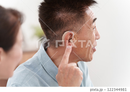 補聴器をつけて会話するシニア男性 122344981