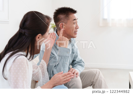 補聴器をつけて会話するシニア男性 122344982