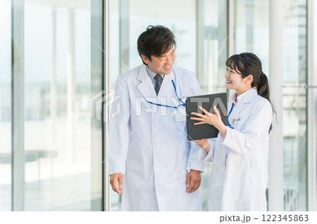 病院の通路で話す医者・医師・医療従事者・ドクター・薬剤師・科学者・研究員の男女 122345863