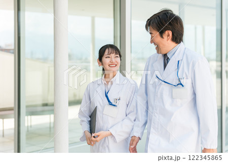 病院の廊下を歩く男女の医師・医者・医療従事者・薬剤師・研究員・科学者（2人） 122345865
