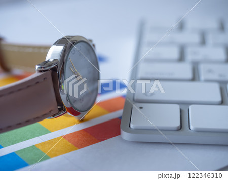 テーブルに置かれたグラフとキーボードと腕時計 122346310