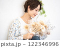 ビューティーイメージ（ドライフラワーを持つショートヘアのミドル女性） 122346996