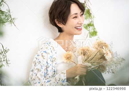 ビューティーイメージ（ドライフラワーを持つショートヘアのミドル女性） 122346998