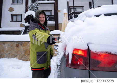 Person Clearing Snow from Car in Winter Landscape Person Clearing Snow from Car in Winter Landscape 122347279
