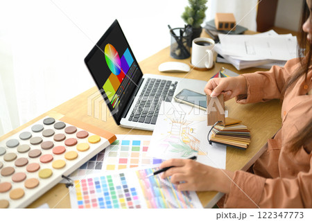 Interior designer reviewing a color palette and working on design sketch Interior designer reviewing a color palette and working on design sketch 122347773