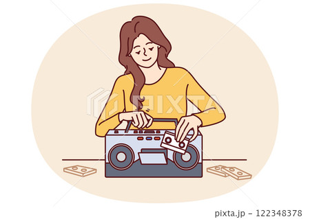 Woman inserts tape cassette into player to turn on music and start party in retro style Woman inserts tape cassette into player to turn on music and start party in retro style 122348378