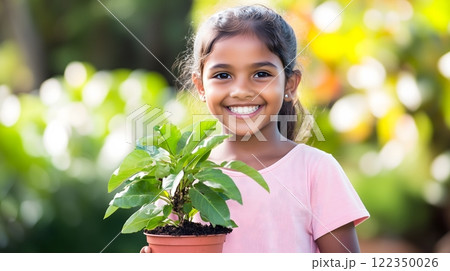 Smiling Girl Holding a Potted Plant in a Colorful Outdoor Garden 122350026