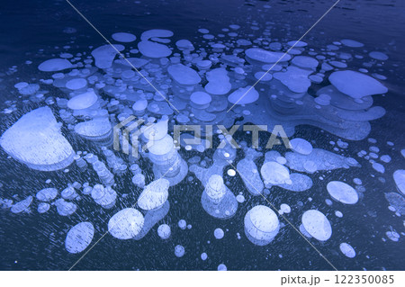 湖面の氷に閉じ込められた空気の気泡 122350085
