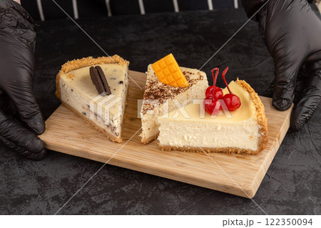 classic cheesecake decorated with cherries, chocolate and cookies on a dark background classic cheesecake decorated with cherries, chocolate and cookies on a dark background 122350094