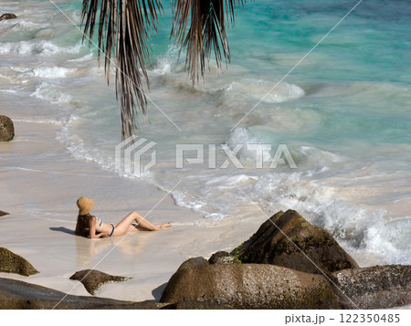 Cute woman sitting on stunning white sand beach Cute woman sitting on stunning white sand beach 122350485
