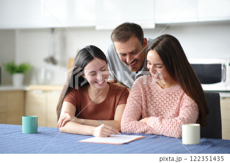 Happy roommates signing lease contract Happy roommates signing lease contract 122351435
