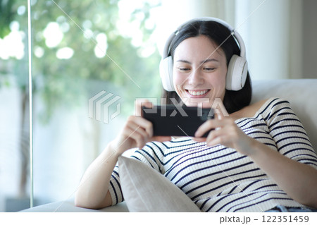 Asian woman using phone to watch videos Asian woman using phone to watch videos 122351459