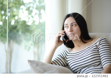 Bored asian woman waiting for attention talking on phone 122351462