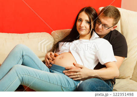 Pregnant woman and man relaxing on sofa 122351498