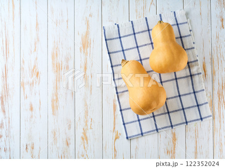butternut pumpkin on a white table, top view. 122352024
