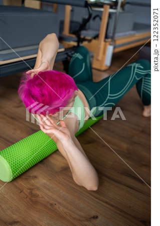 Discover the benefits of Pilates with a Foam Roller in a modern and inviting studio 122352071