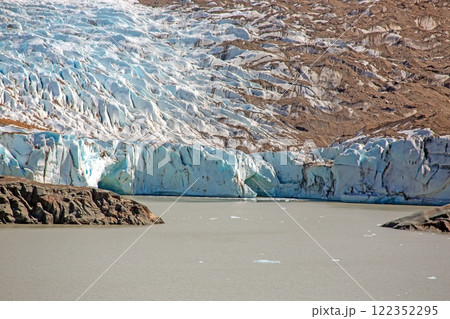 Close view of the Cerro Torre glacier edge with ice formations and a meltwater lake 122352295