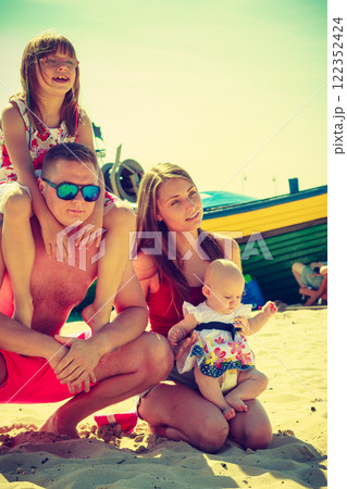 Family posing at beach near sea 122352424