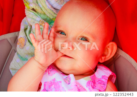 Baby lying stroller with finger in mouth Baby lying stroller with finger in mouth 122352443