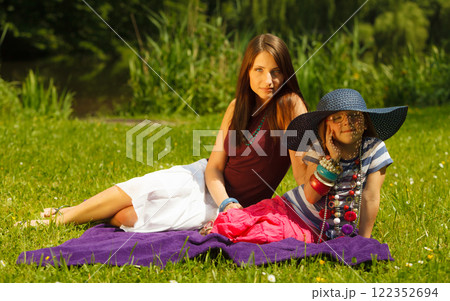 Mother and daughter little girl having picnic in park 122352694