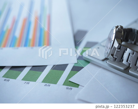 テーブルに置かれたグラフとキーボードと腕時計 テーブルに置かれたグラフとキーボードと腕時計 122353237