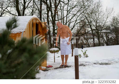 Senior couple entering small sauna. Winter spa weekend getaway for elderly people. Senior couple entering small sauna. Winter spa weekend getaway for elderly people. 122353282