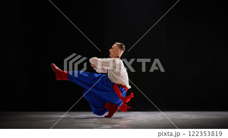 Performer in spotlight, balancing agility and grace, one leg high in extension, embodying celebration of identity through dynamic movement. 122353819