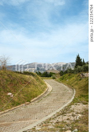 Winding Pathway Through Green Hills and Mountains 122354764