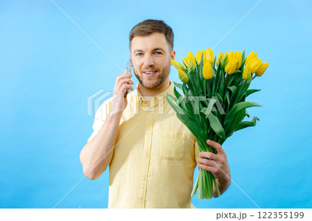 Man holding bouquet of flowers and cell phone 122355199