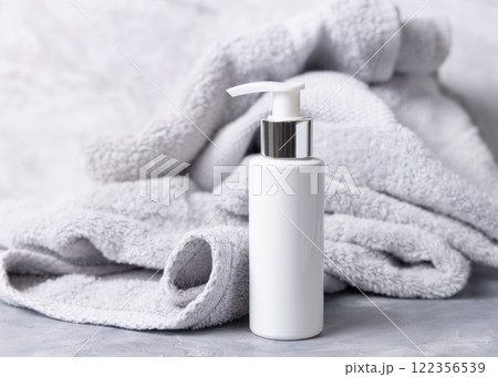 White blank one pump cream bottle near light grey bath towel closeup, cosmetic mockup 122356539