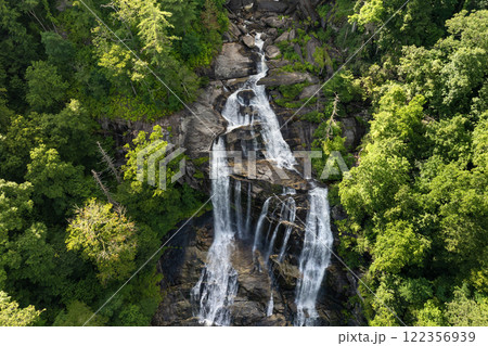 Beautiful landscape of high waterfall with falling down clear water from rocky boulders between green lush woods. Whitewater Falls in Nantahala National Forest, North Carolina, USA Beautiful landscape of high waterfall with falling down clear water from rocky boulders between green lush woods. Whitewater Falls in Nantahala National Forest, North Carolina, USA 122356939