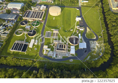 Aerial view of modern water cleaning facility at urban wastewater treatment plant. Purification process of removing undesirable chemicals, suspended solids and gases from contaminated liquid Aerial view of modern water cleaning facility at urban wastewater treatment plant. Purification process of removing undesirable chemicals, suspended solids and gases from contaminated liquid 122357025