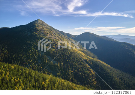 Aerial view of high hills with dark pine forest trees at autumn bright day. Amazing scenery of wild mountain woodland 122357065