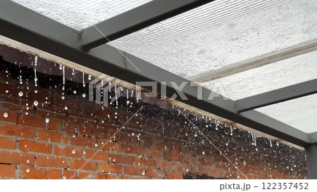Heavy rain drumming on the transparent plexiglass roof. Beautiful rainy scene on summer day. Concept of tranquility nature scene. Close up Slow motion Heavy rain drumming on the transparent plexiglass roof. Beautiful rainy scene on summer day. Concept of tranquility nature scene. Close up Slow motion 122357452